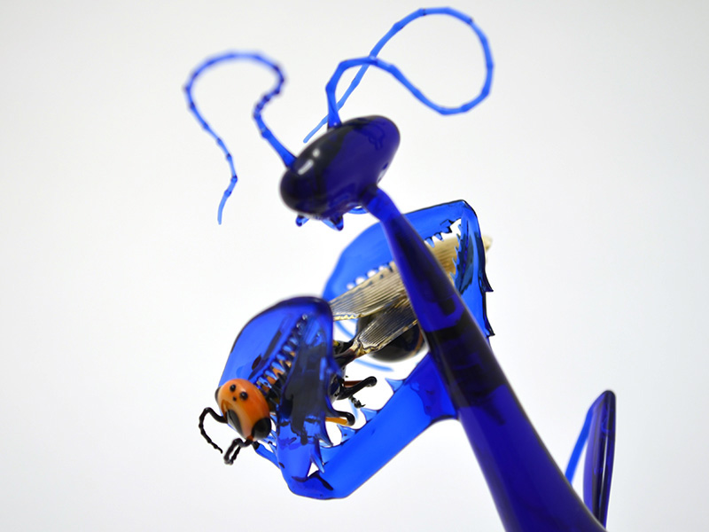 Indigo Mantis Eating Wasp, glass mantis by Wesley Fleming
